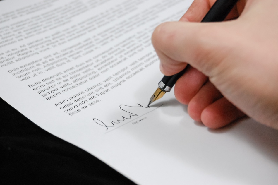 Egy személy aláír egy dokumentumot