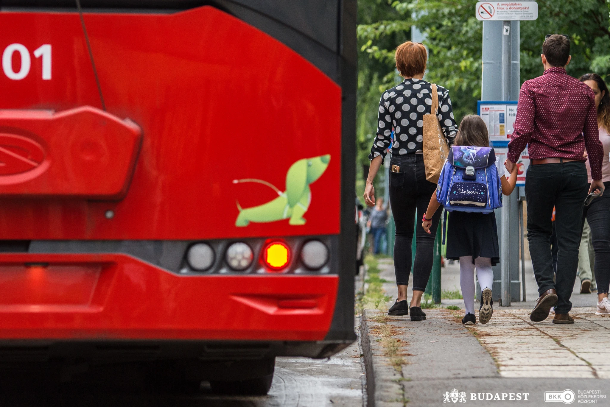 Iskolás kislány a szüleivel száll fel a trolira