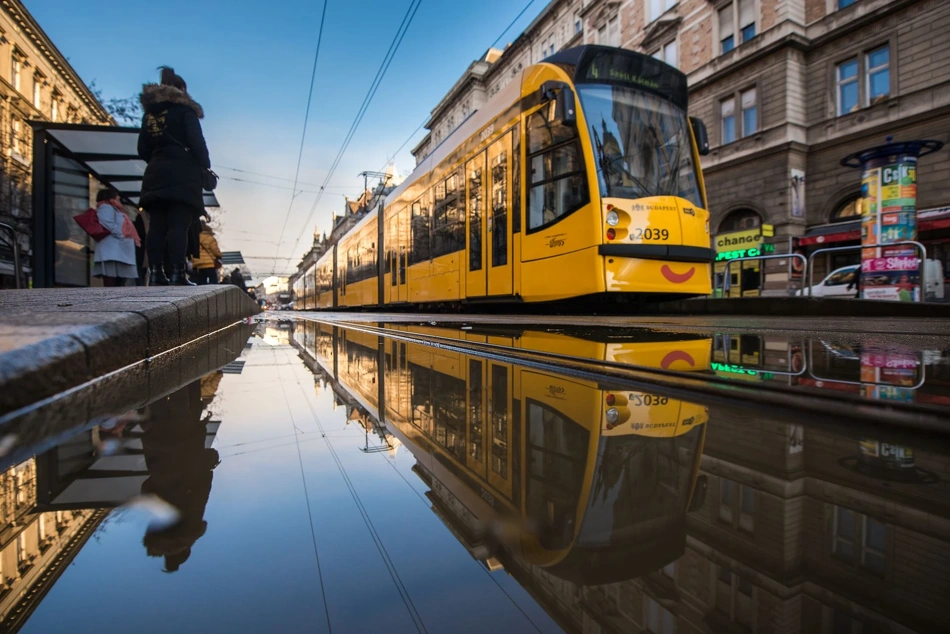 Egy Siemens Combino villamos tükröződik a vízben a Nagykörúton