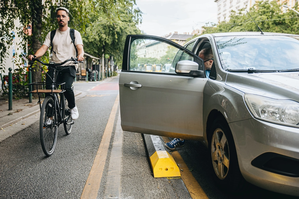 Kerékpárral közlekedő és parkoló autó a Nagykörúton